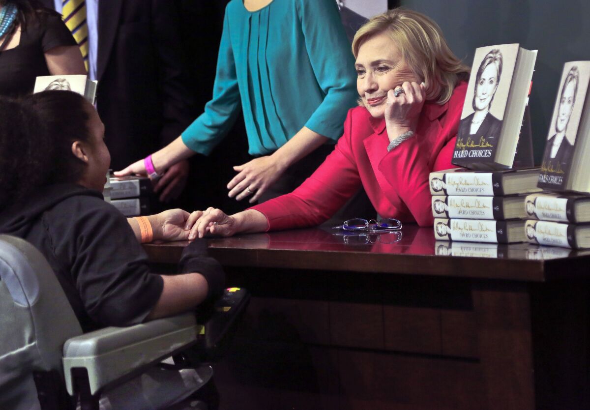 Hillary Rodham Clinton listens before signing a copy of her new book for a woman Tuesday at Barnes and Noble bookstore in New York.
