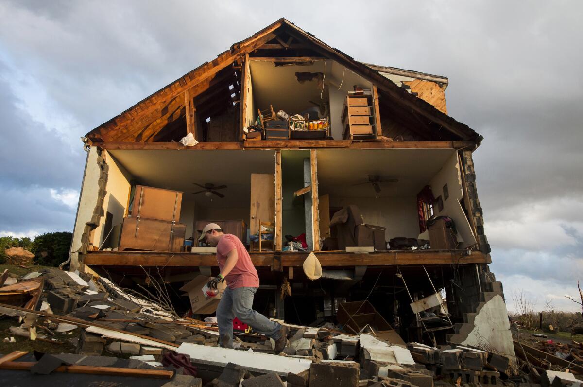 Nick Mobley ayuda a despejar una casa de un amigo detsruida por una torementa en el condado Appomattox, Virginia. Una serie de tormentas llevó tornados a la costa este de Estados Unidos.