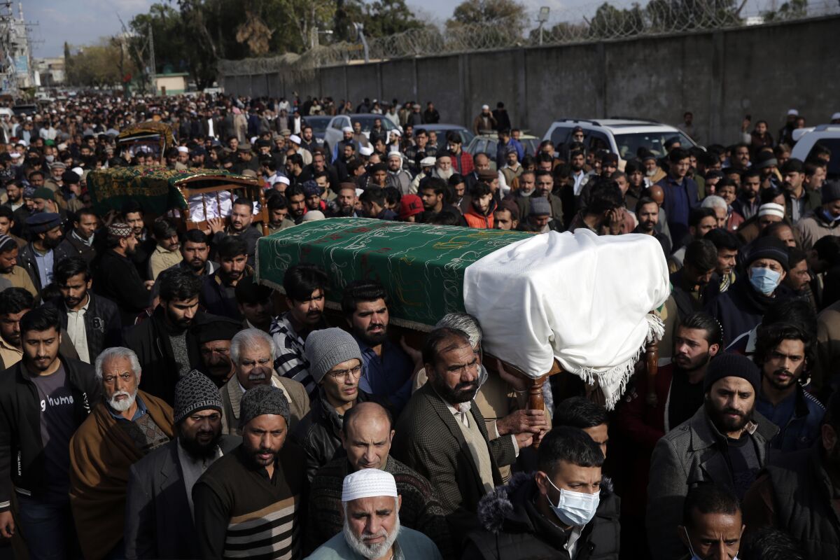 People carry six bodies from one family that were killed after being stuck in their vehicles overnight during a heavy snowstorm as temperatures plummeted, in the area of the Murree Hills resort, in Rawalpindi, adjacent to Pakistan's capital of Islamabad, Sunday, Jan. 9, 2022. Officials say at least 22 people, including 10 children, died in the popular mountain resort town. (AP Photo/Rahmat Gul)