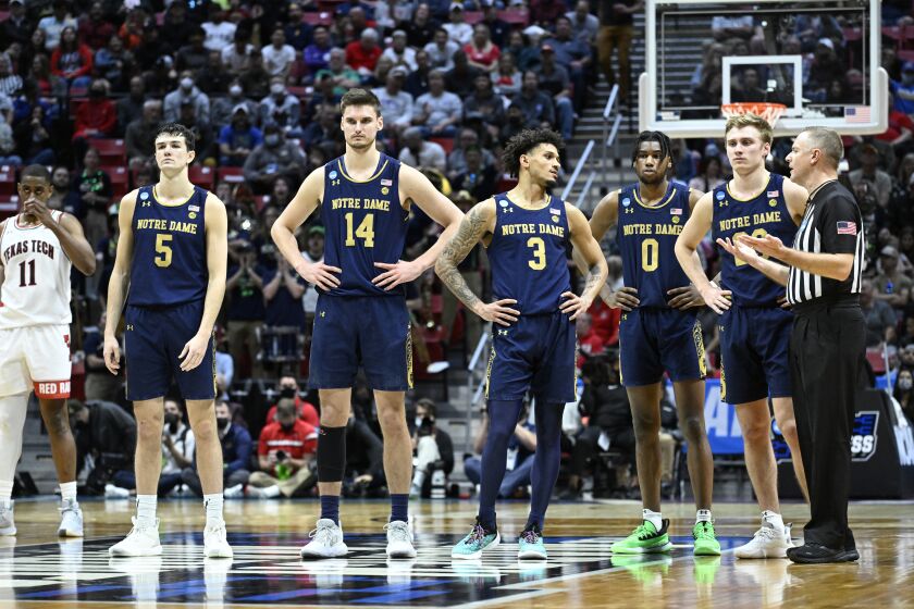 Notre Dame players, including forward Nate Laszewski (14) and guard Prentiss Hubb (3) stand on the court late in the second half of a second-round NCAA college basketball tournament game against Texas Tech, Sunday, March 20, 2022, in San Diego. Texas Tech won 59-53. (AP Photo/Denis Poroy)