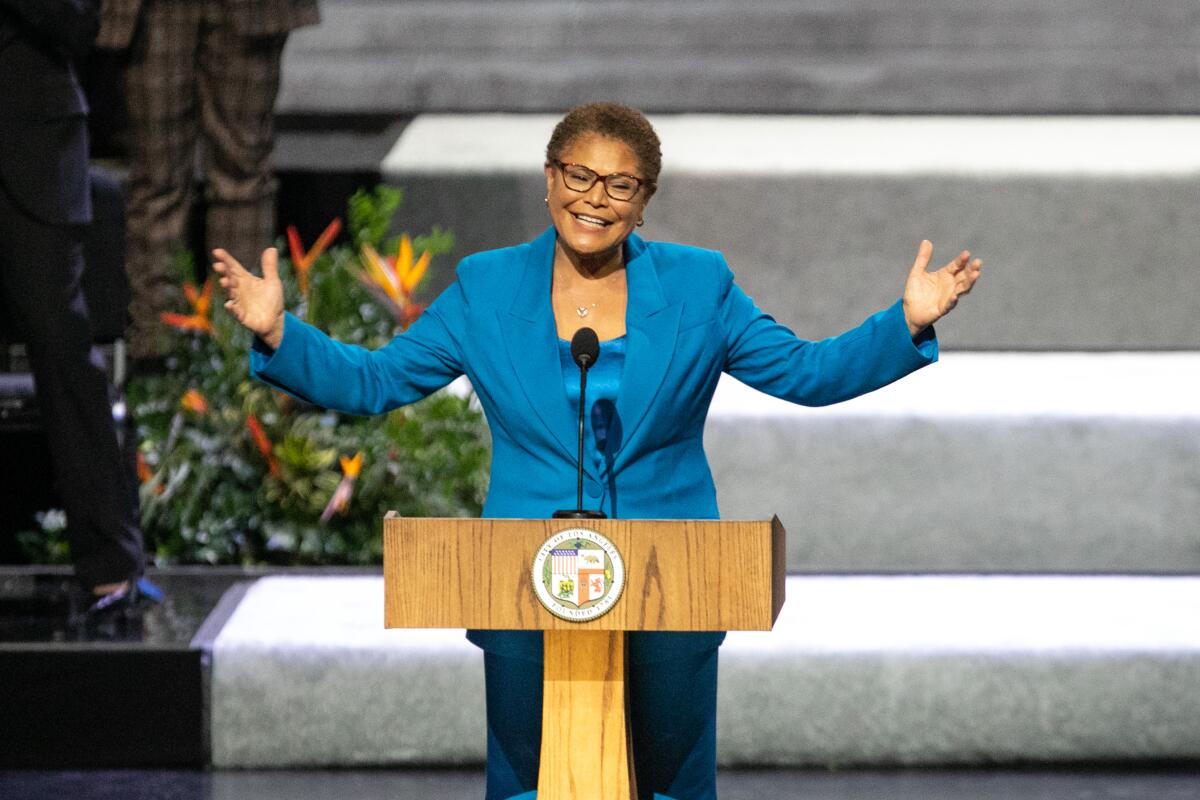 Mayor Karen Bass speaking at a lectern at the Microsoft Theater