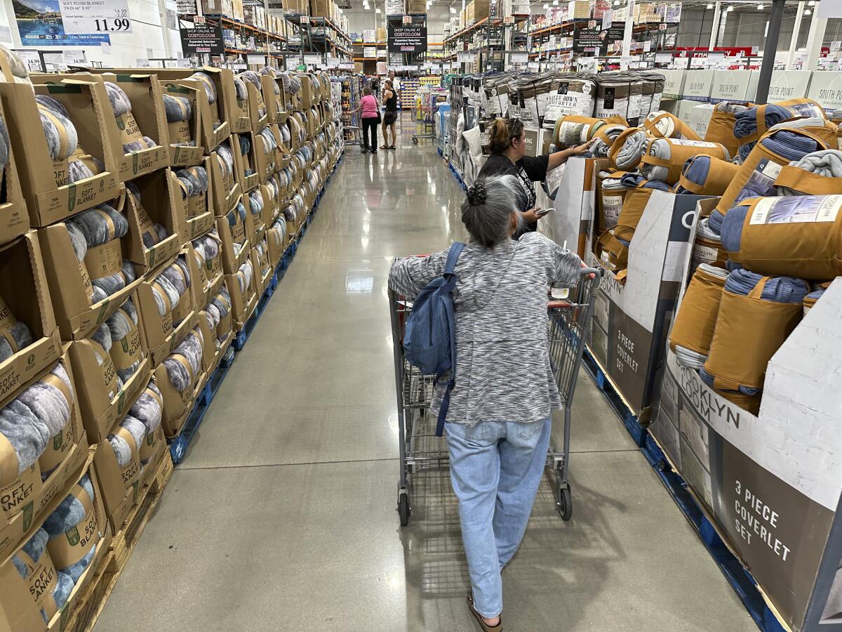 Shoppers look at blankets on sale in a Costco warehouse 