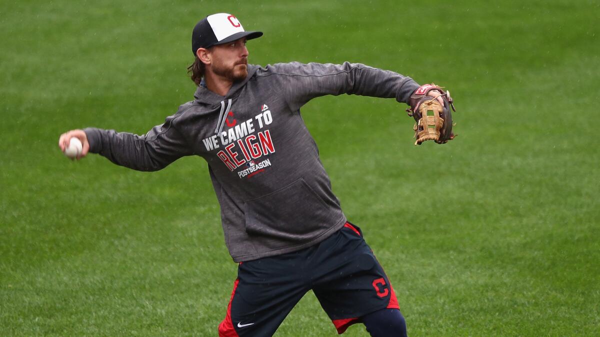 Indians starter Josh Tomlin loosens up on the soggy Fenway Park field after Game 3 of the ALDS was postponed until Monday.