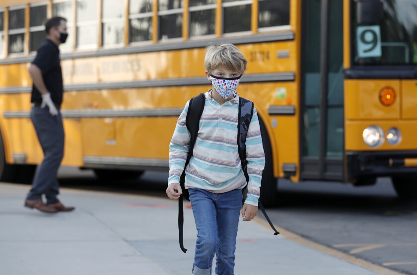 A student arrives on the bus as kids return for in-person learning in Laguna Beach.