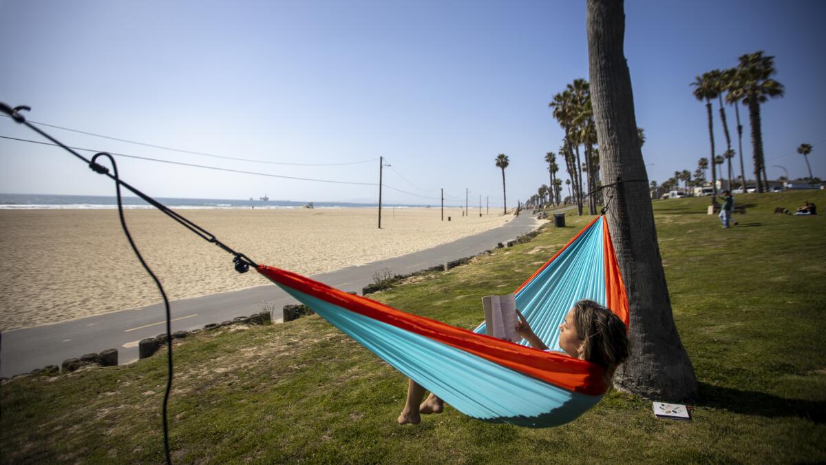 Kylie Wortham, who was laid off when her company closed due to the pandemic, relaxes in a hammock in Huntington Beach.