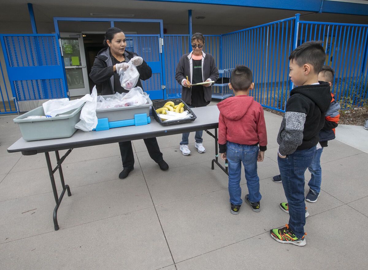 Students received their grab-and-go school breakfasts at La Mirada Elementary School, part of the San Ysidro School District, on Monday, March 16, 2020, the first day of school closures under the COVID-19 virus school shutdown.