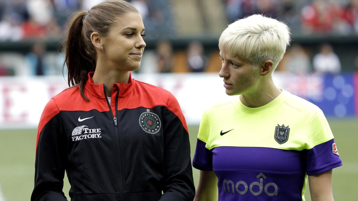 Thorns forward Alex Morgan, left, and Reign forward Megan Rapinoe stare down each other before an NWSL game.