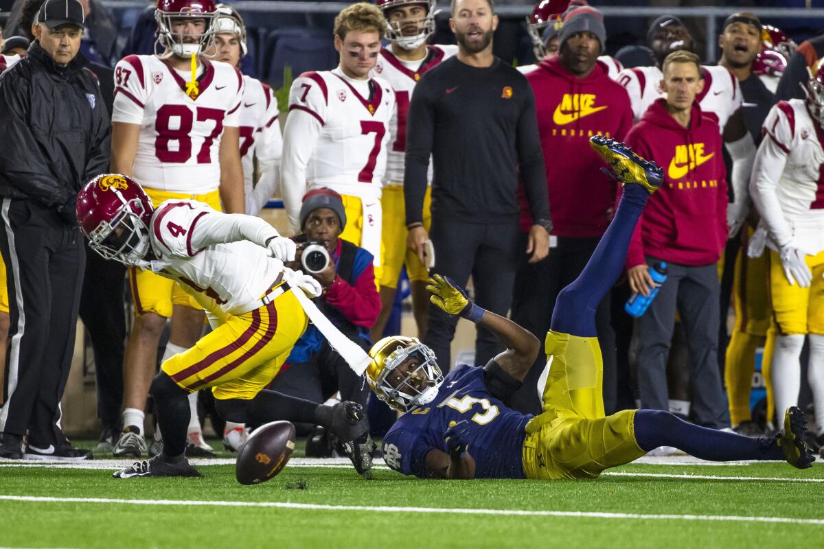 Notre Dame cornerback Cam Hart (5) forces USC receiver Mario Williams (4) to fumble the ball.