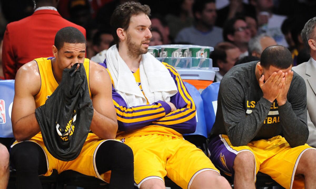 Lakers teammates Xavier Henry, left, Pau Gasol, center, and Kendall Marshall react on the bench during the fourth quarter of a blowout loss to the Clippers on March 6. The Lakers' losing ways have taken a toll on the players and the fans.