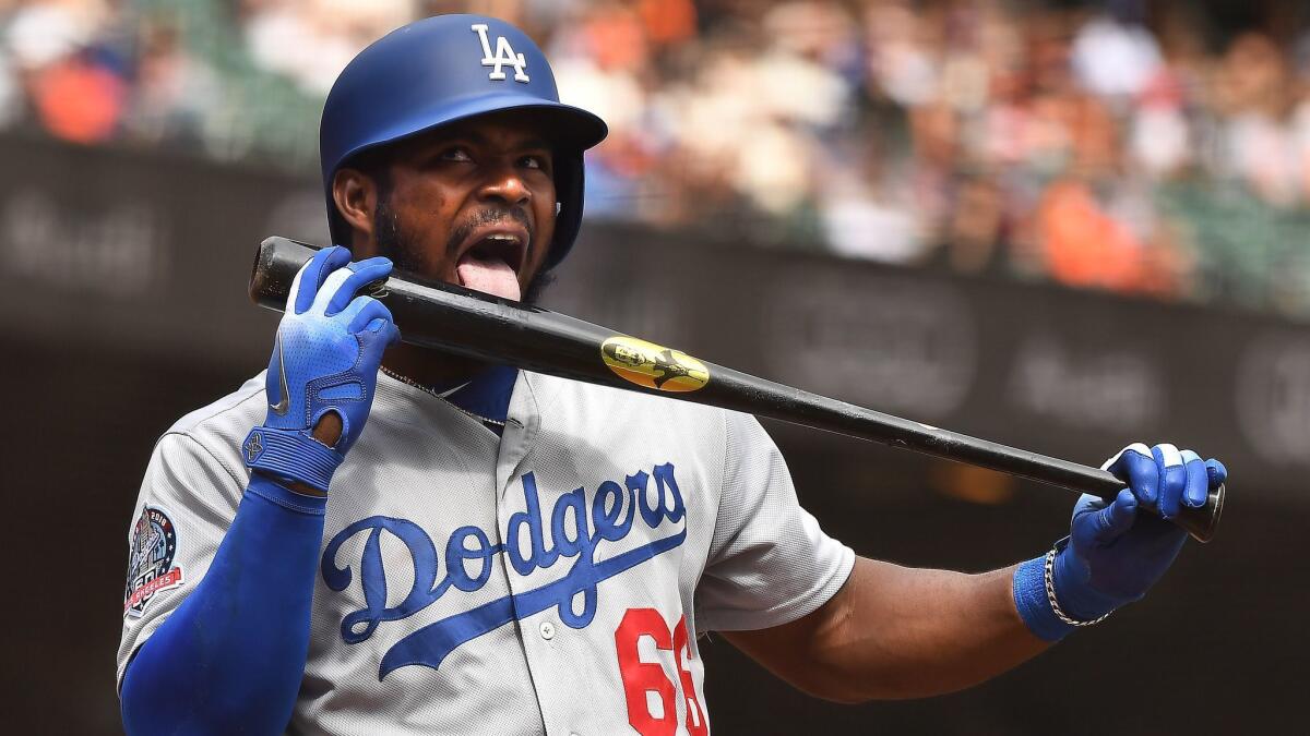 Dodgers' Yasiel Puig licks his bat before hitting a solo home run against the Giants.