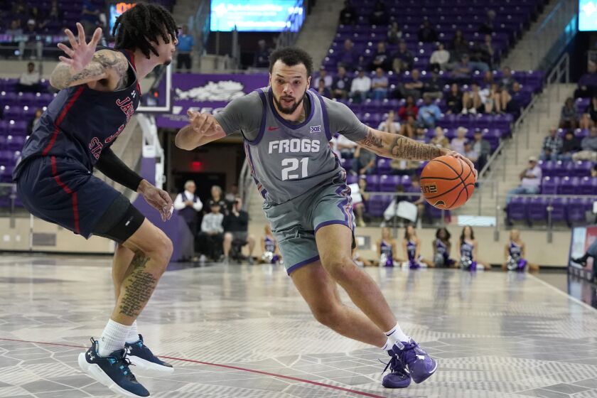 TCU forward JaKobe Coles (21) drives against Jackson State forward Trace Young (3) during the first half of an NCAA college basketball game in Fort Worth, Texas, Tuesday, Dec. 6, 2022. (AP Photo/LM Otero)