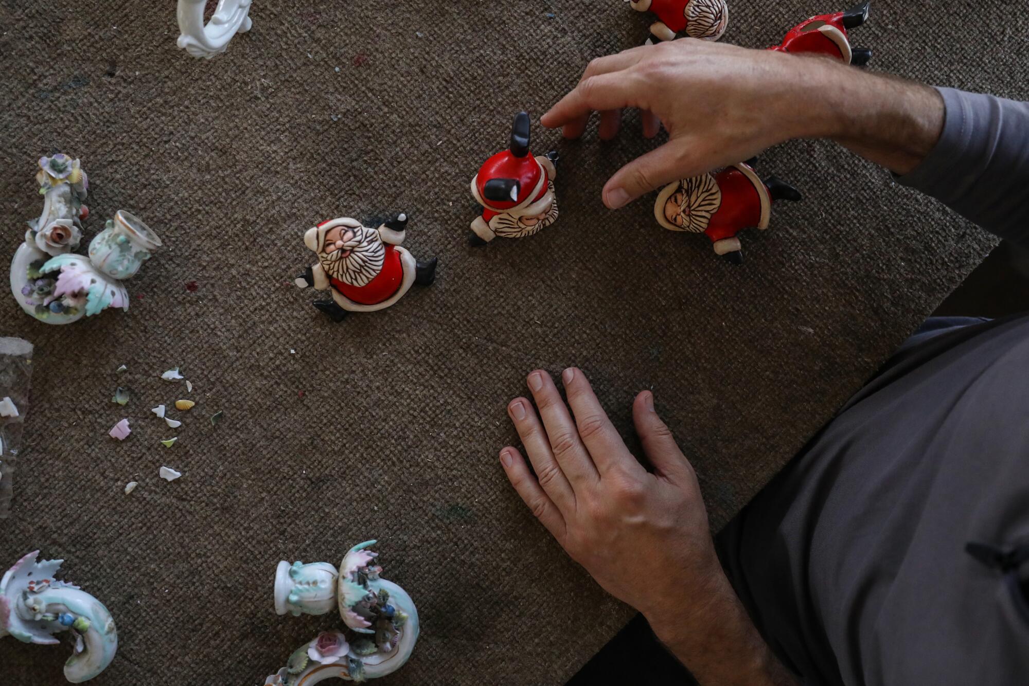 Ceramic Santa Claus figurines on a work table.