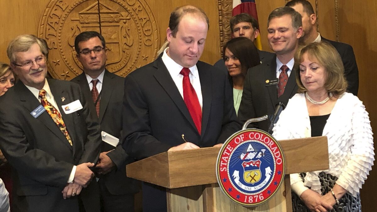 Colorado Gov. Jared Polis signs into law Senate Bill 19-181 at the state Capitol in Denver on Tuesday.