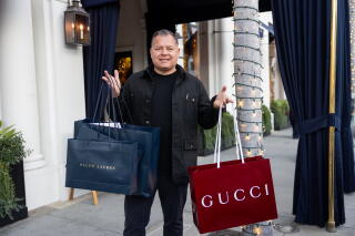 John Anderson holds his shopping bags from Ralph Lauren and Gucci
