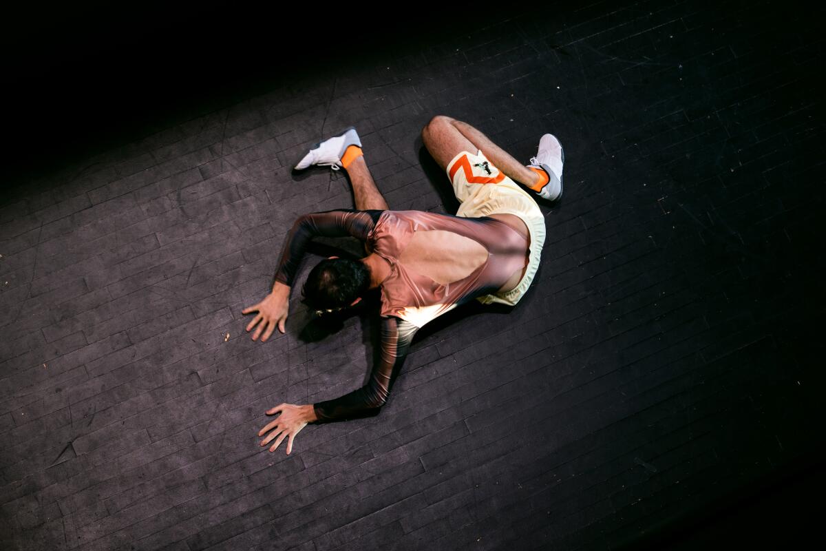 A dancer folded over on the floor.