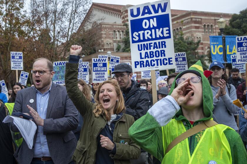 LOS ANGELES, CA-DECEMBER 2, 2022: Graeme Blair, left, an associate professor of political science at UCLA and Anna Markowitz, 2nd from left, an assistant professor of education at UCLA, show their support for graduate student workers at UCLA on strike, calling for university to offer the students a contract with a dramatic increase in pay and benefits to match the skyrocketing cost of living in California. (Mel Melcon / Los Angeles Times)