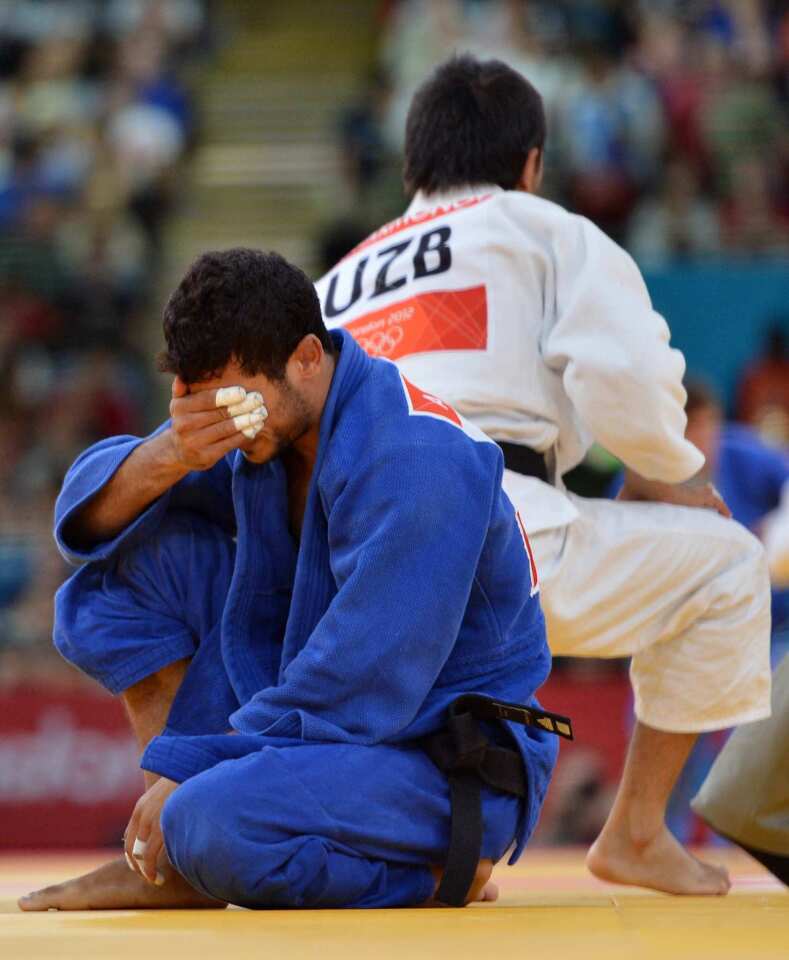Libya's Ahmed Yousef Elkawiseh, in blue, reacts after losing against Uzbekistan's Mirzahid Farmonov during the men's 66kg judo event at the London 2012 Olympic Games.