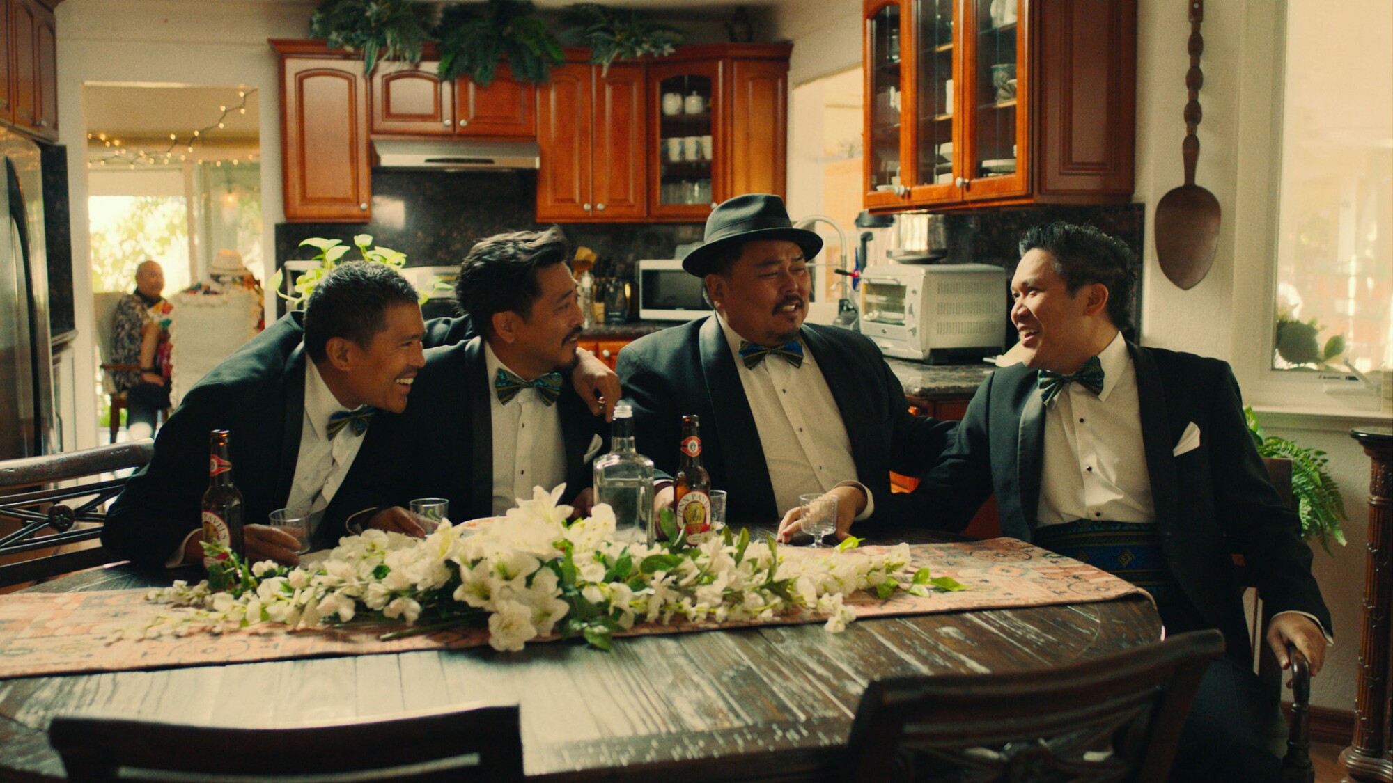 Four men in tuxes at a kitchen table
