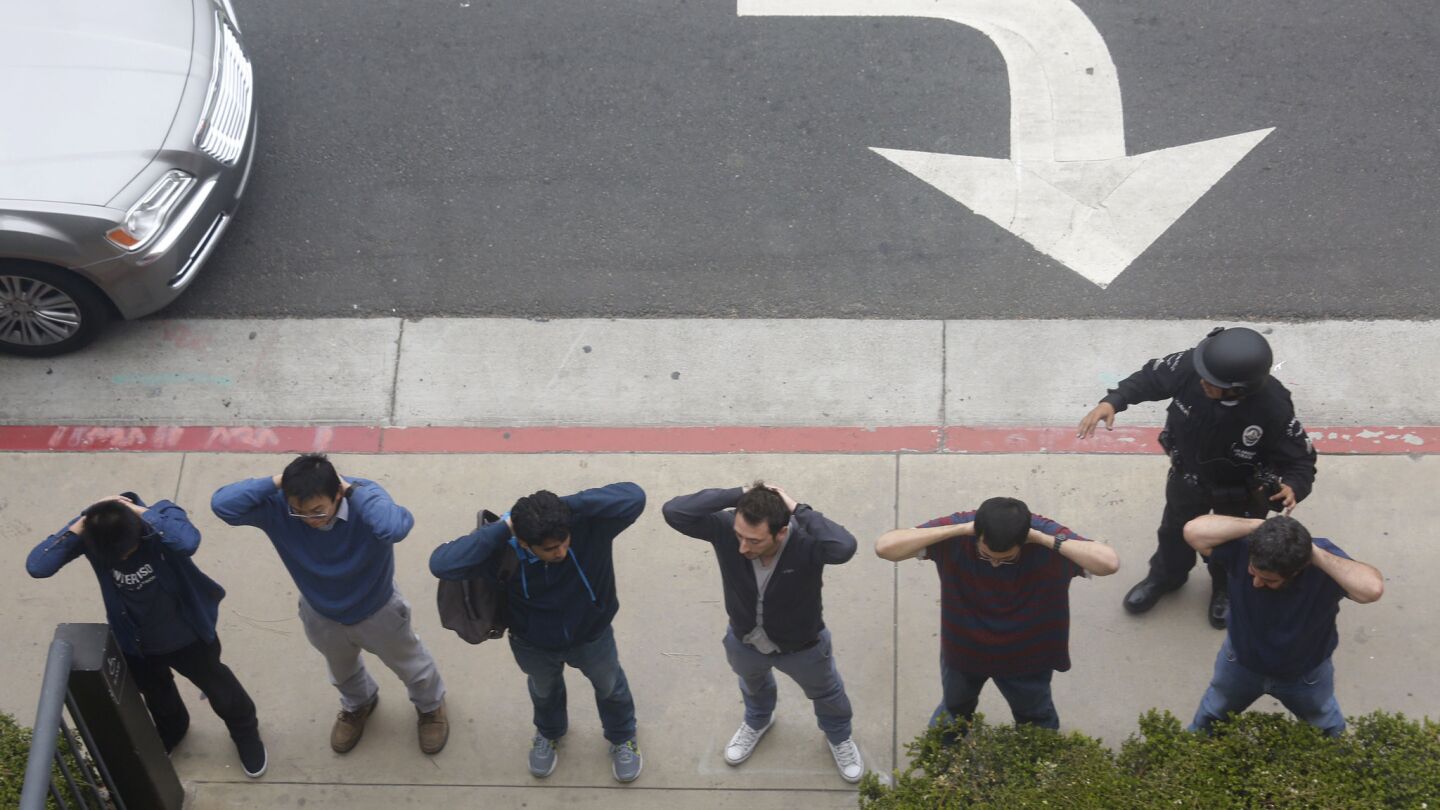 People are frisked at the scene of a shooting at UCLA on Wednesday morning.