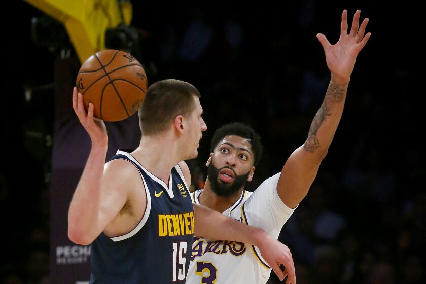 LOS ANGELES, CALIF. - DEC. 22, 2019. Lakers forward Anthony Davis defends against Nuggets center Nikola Jokic in the first quarter Sunday night, Dec. 22, 2019, at Staples Center in Los Angeles (Luis Sinco/Los Angeles Times)