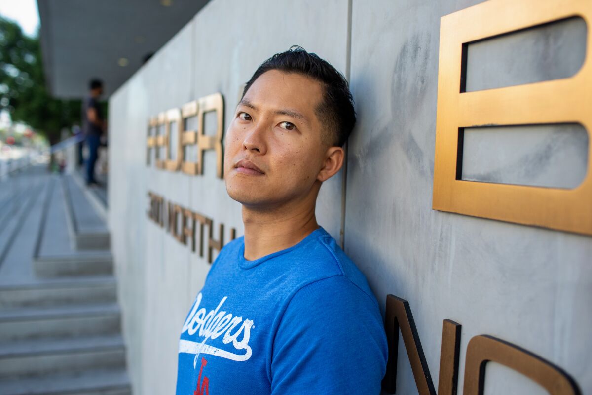 Justin Chung leans against a wall and looks at the camera outside the federal building in Los Angeles.