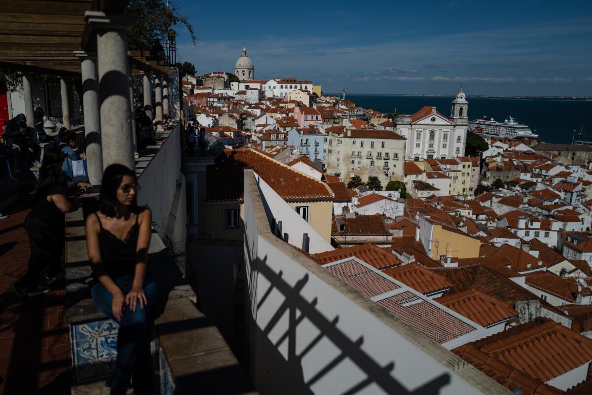 People sit and look out from a high point at buildings.