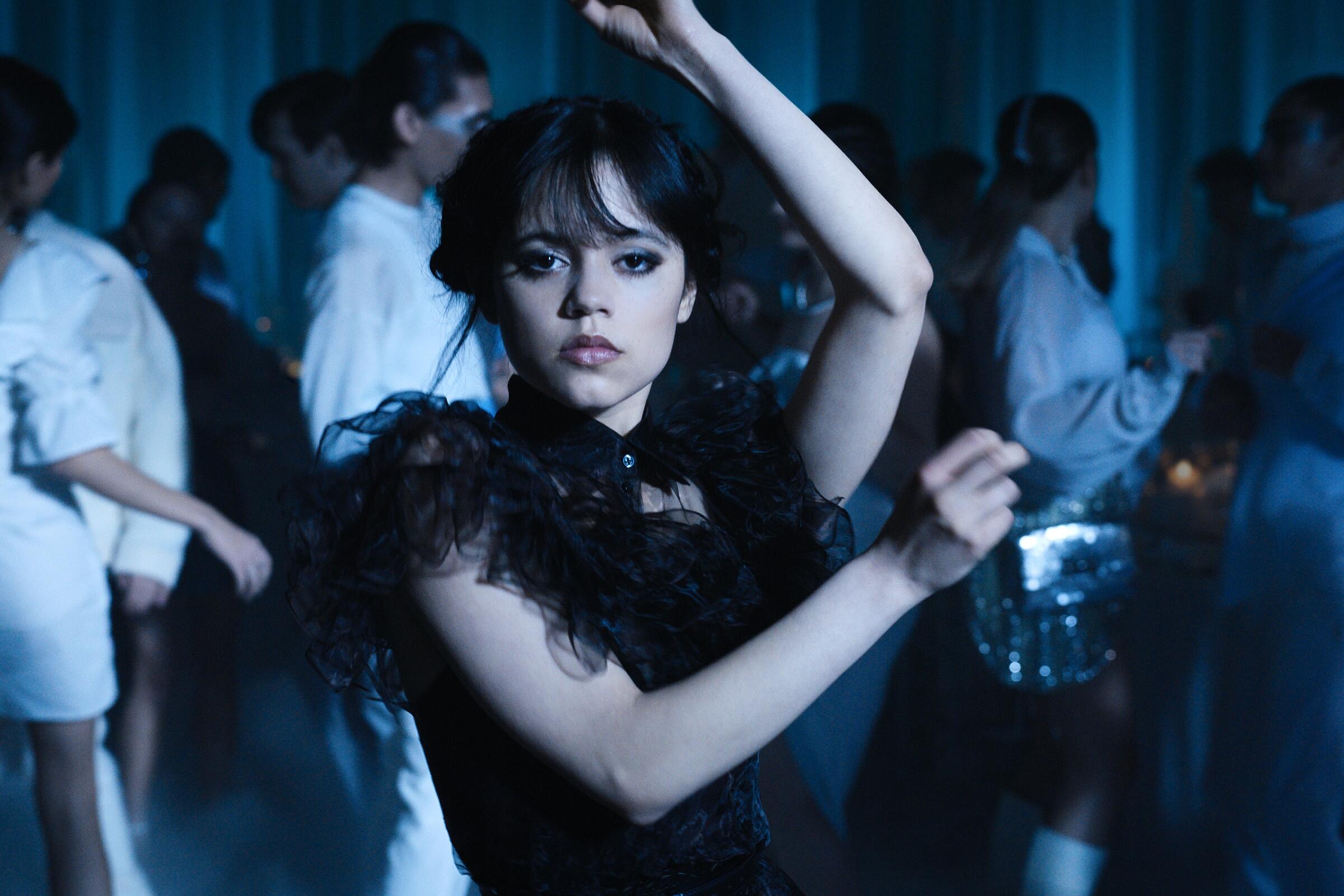 Jenna Ortega dances in a black party dress in a scene from "Wednesday."