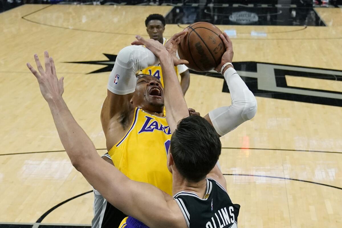 Lakers guard Russell Westbrook is fouled by San Antonio Spurs forward Zach Collins as he drives to the basket.