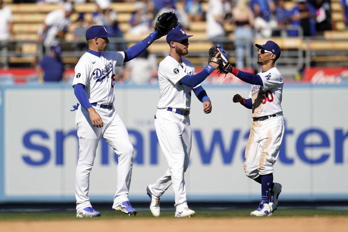 Dodgers outfielders, from left, Trayce Thompson, Cody Bellinger and Mookie Betts celebrate a 10-3 win.