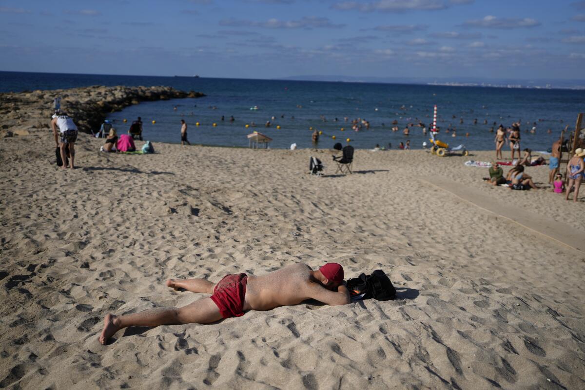 A man rests on the beach in Haifa, Israel.