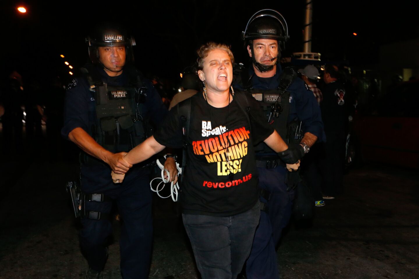 An activist is arrested by LAPD Sunday night after police gave orders to leave the area along 107th Street.