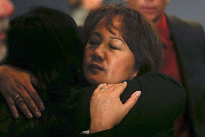 Trudy Raymundo, head of the San Bernardino County Department of Public Health, gets a hug immediately after a news conference as county offices reopened.