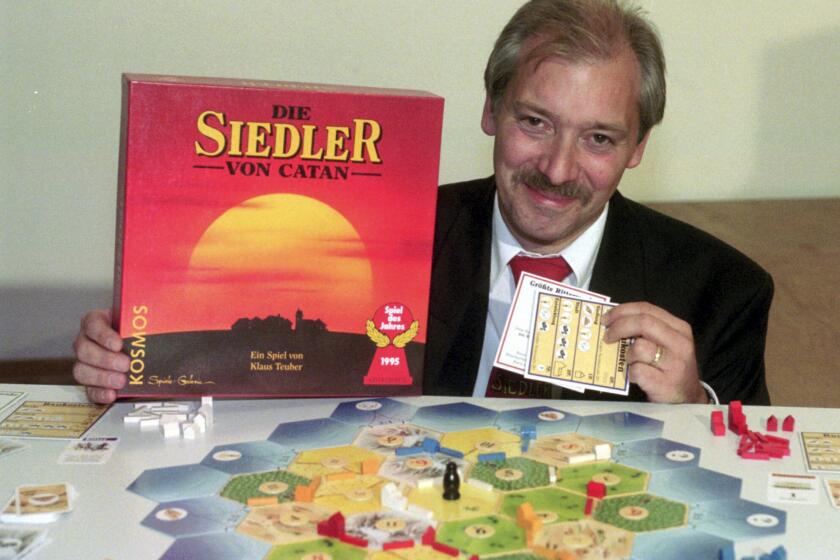 FILE - Klaus Teuber, a dental technician from Darmstadt, presents his game "The Settlers of Catan", Friday, Sept. 29, 1995, in Frankfurt, Germany. Teuber, creator of the hugely popular Catan board game in which players compete to build settlements on a fictional island, passed away on April 1, 2023 after a short and serious illness, according to a family statement. He was 70. (AP Photo/Bernd Kammerer, File)