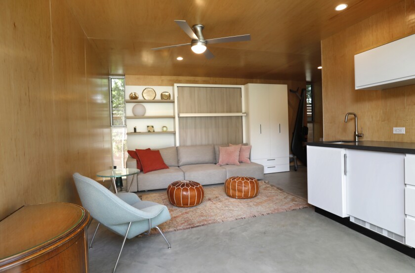 The living room with narrow, vertical windows and built-in shelves.