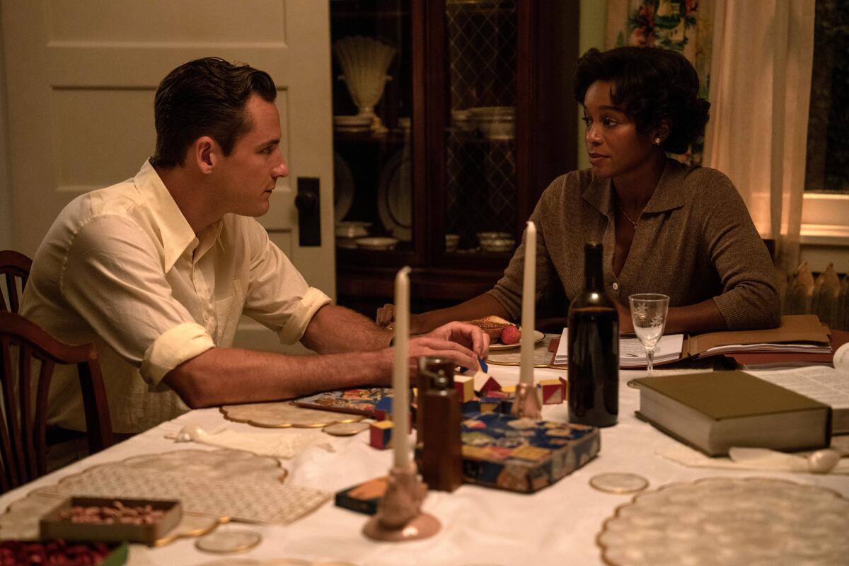 Actors Lewis Pullman and Aja Naomi King sit in a kitchen in a scene from "Lessons in Chemistry."