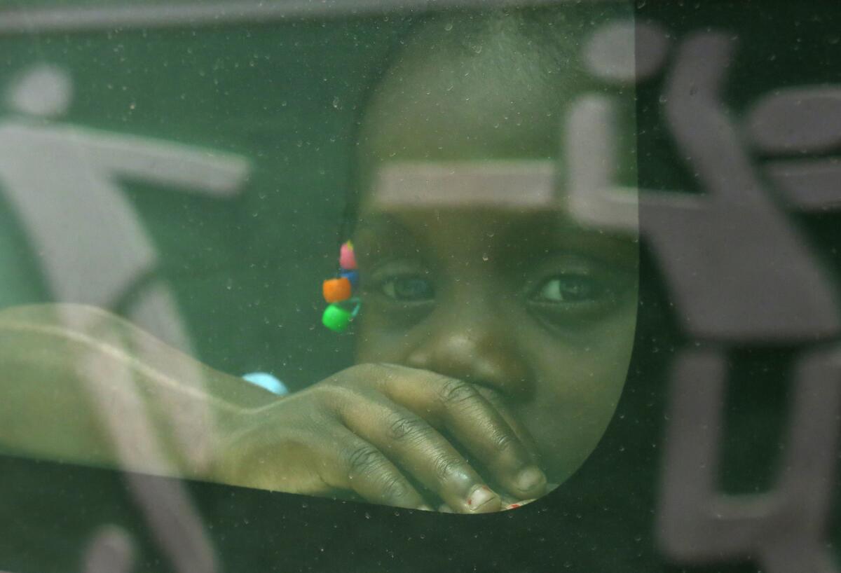 Una niña nacida en República Dominicana de padres haitianos mira a través de la ventana de un vehículo del gobierno mientras es trasladada junto a su familia a la frontera con Haití, en Santo Domingo.