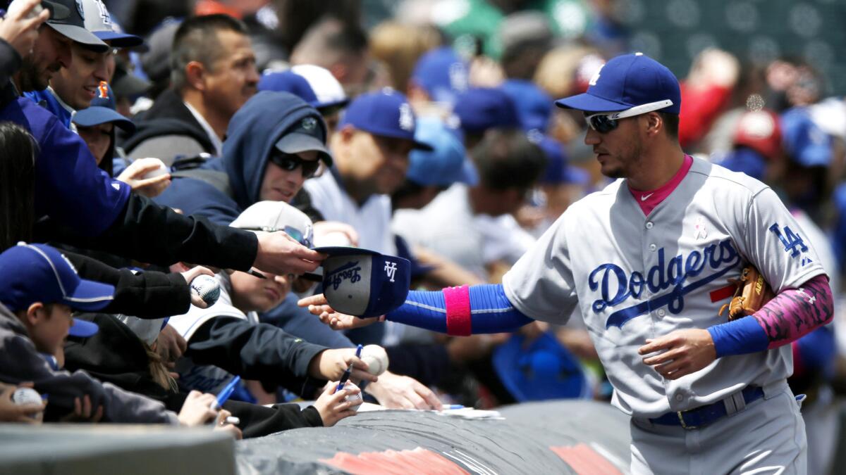 Dodgers third baseman Alex Guerrero signs autographs before a game against the Rockies in Denver on May 10.