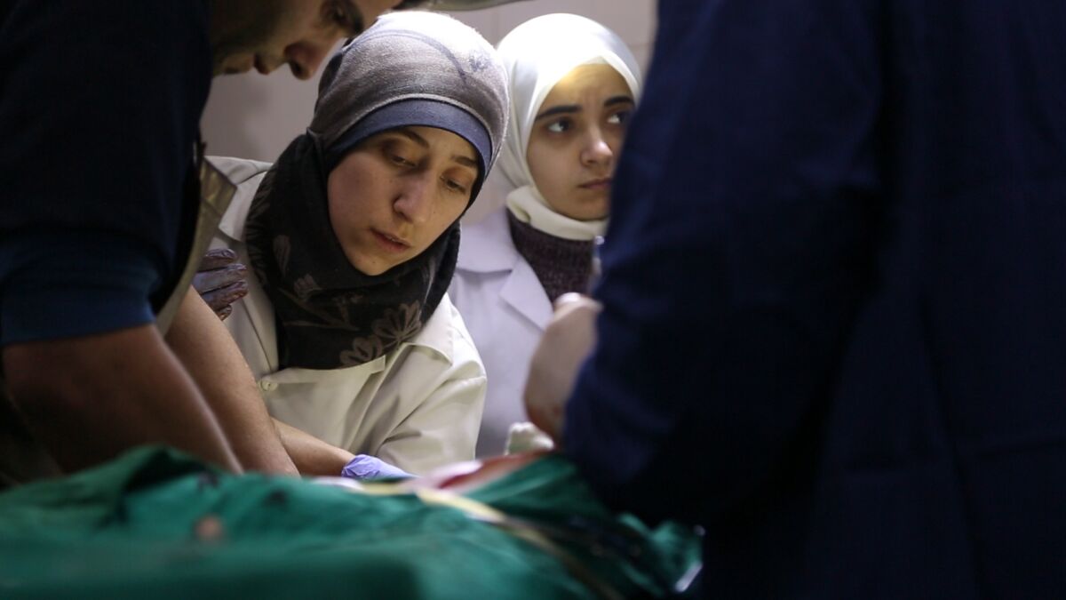 Al Ghouta, Syria - Dr. Amani (center) and Dr Alaa (right) in the operating room in a scene from “The Cave."