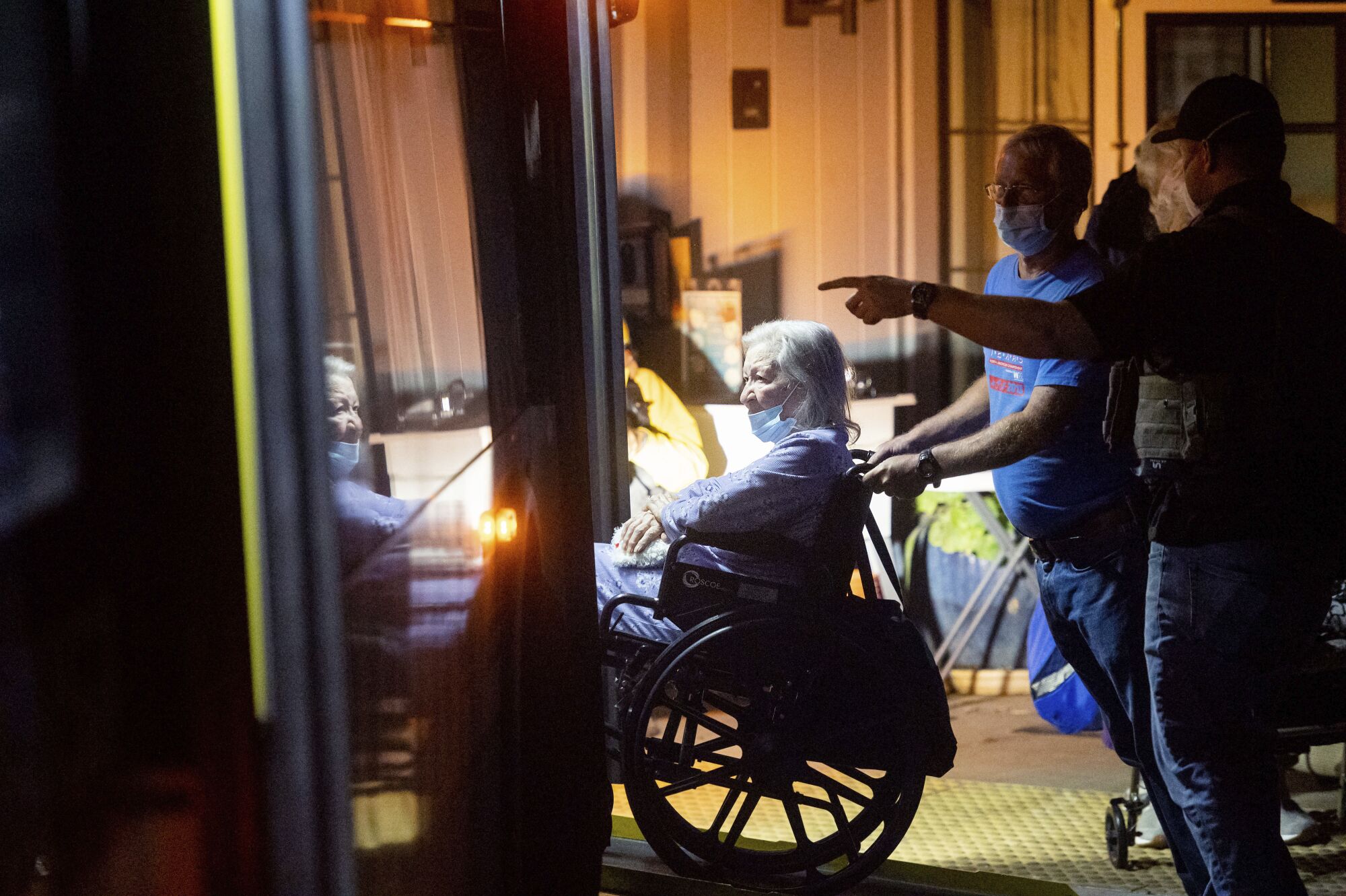 An emergency responder evacuates an Oakmont Gardens resident in a wheelchair.