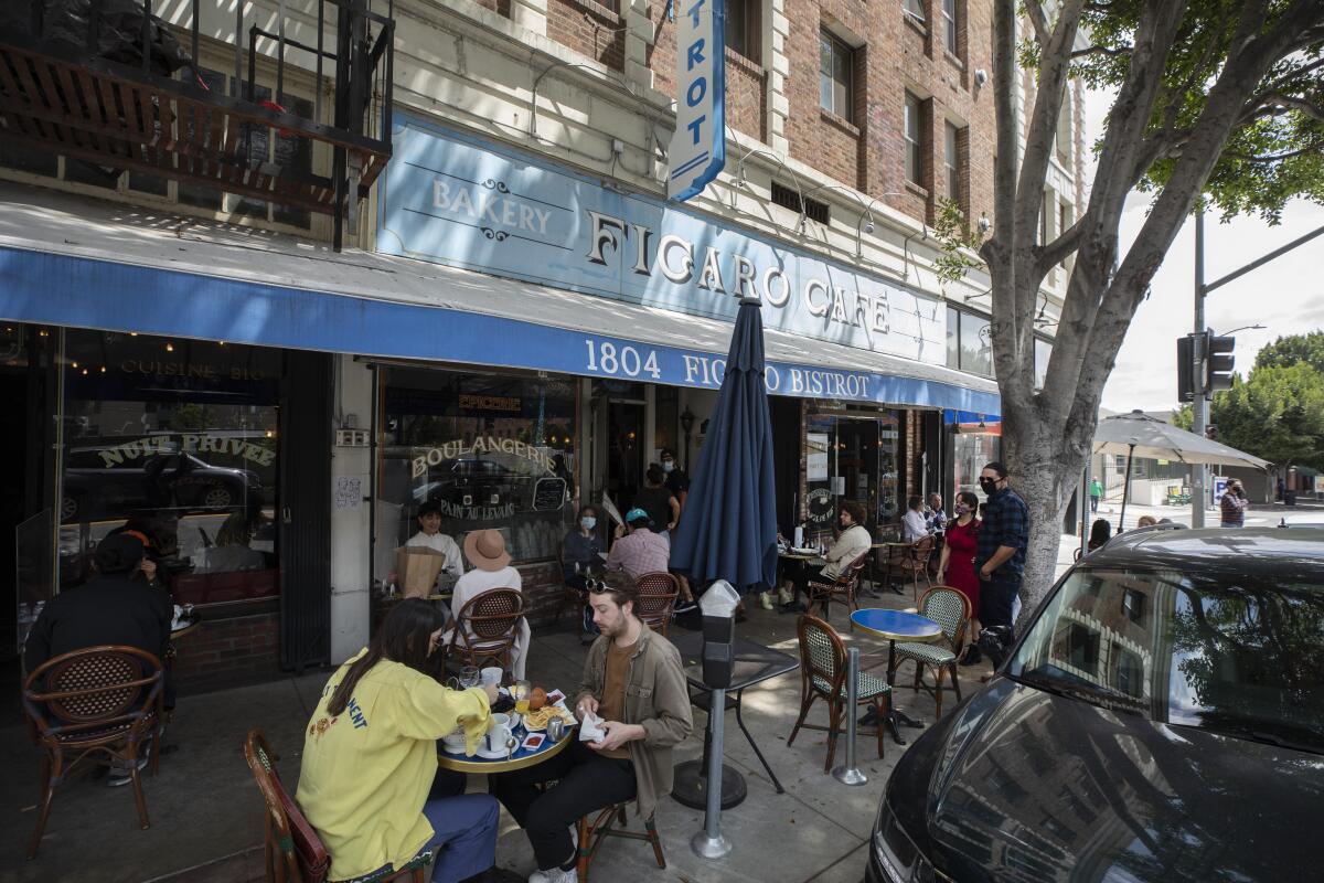 A lunch crowd fills the sidewalk tables at Figaro Bistrot