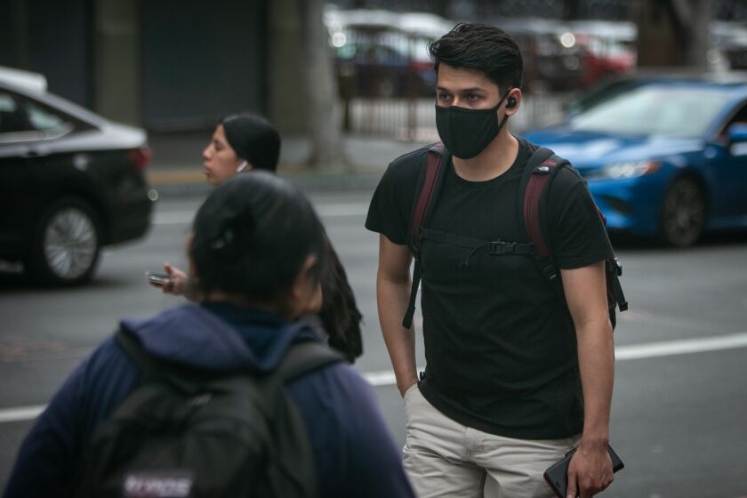 A A person walks in Downtown LA near the corner of 7th and Figueroa wearing a protective mask on Thursday, February 27, 2020 in Los Angeles, California. (Jason Armond / Los Angeles Times)