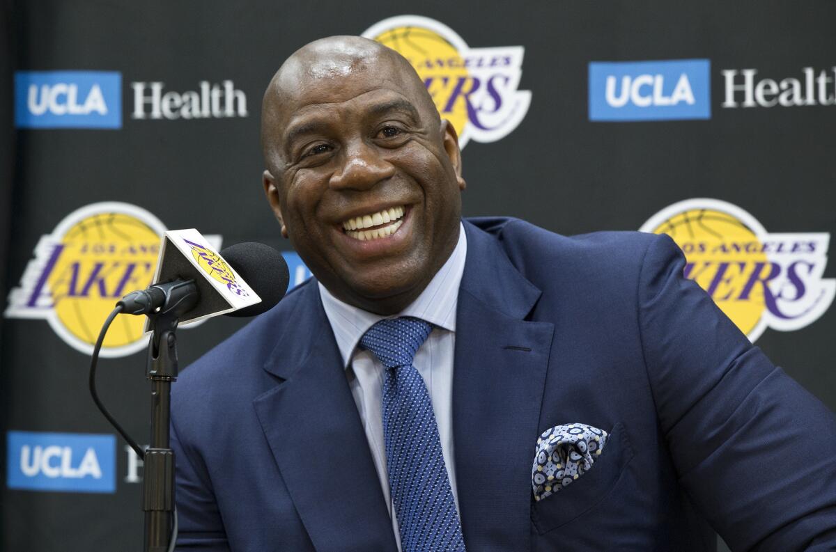 Los Angeles Lakers president of basketball operations, Earvin "Magic" Johnson, smiles as he introduces new draft players, Moritz Wagner, originally from Germany, the 25th pick in the 2018 NBA Draft and guard Sviatoslav Mykhailiuk, originally from Ukraine, at the UCLA Health Training Center in El Segundo, Calif., Tuesday, June 26, 2018. Magic Johnson is betting his job on his free-agent recruiting skills for the Los Angeles Lakers. Johnson says he will step down as the Lakers' president of basketball operations if he can't persuade an elite free agent to sign with his club within the next two summers.
