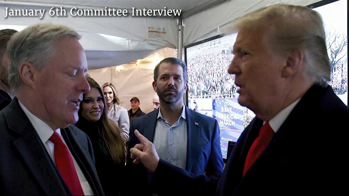 Donald Trump (der) hablando con el jefe de despacho de la Casa Blanca Mark Meadows