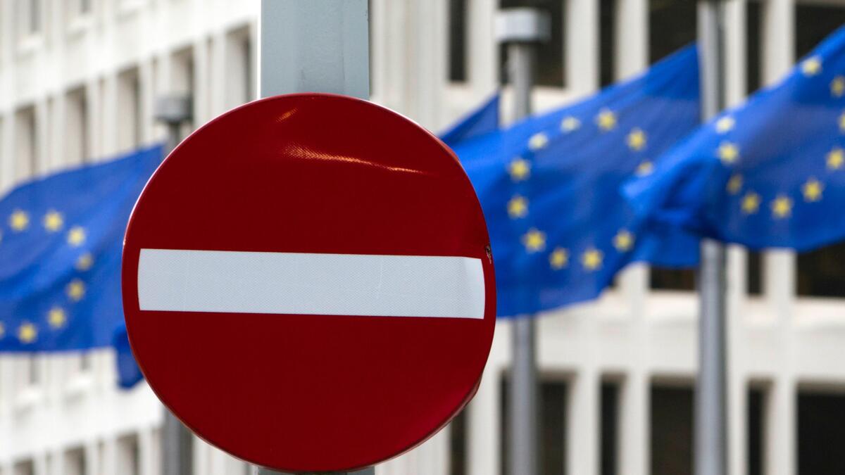 EU flags flutter in the wind behind a no-entry street sign in front of EU headquarters in Brussels on Friday, June 24.