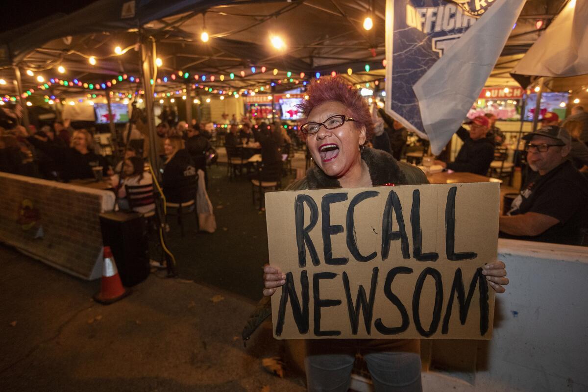 Maggie Assaele of Westlake Village holds a sign that says "Recall Newsom."