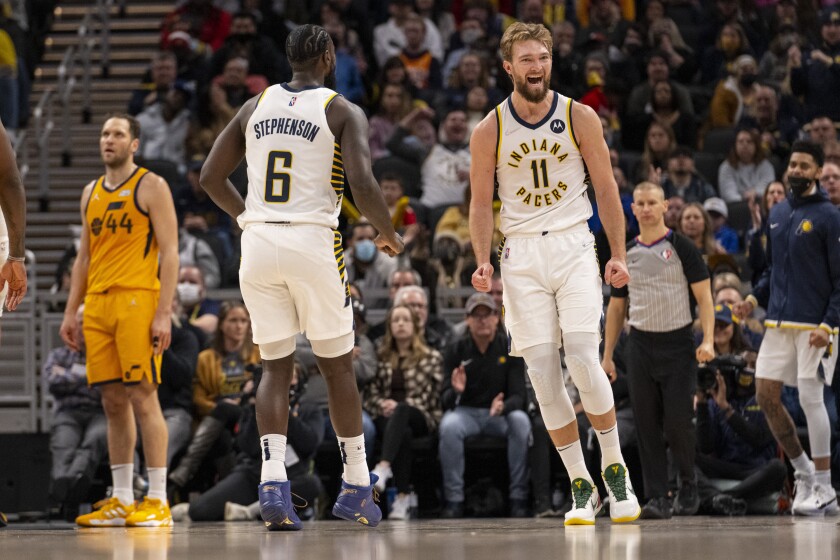 Indiana Pacers forward Domantas Sabonis (11), right, reacts after scoring during the second half of an NBA basketball game against the Utah Jazz in Indianapolis, Saturday, Jan. 8, 2022. (AP Photo/Doug McSchooler)