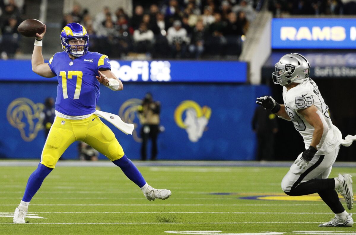 Rams quarterback Baker Mayfield finds an open receiver while running away from Raiders lineback Luke Masterson.