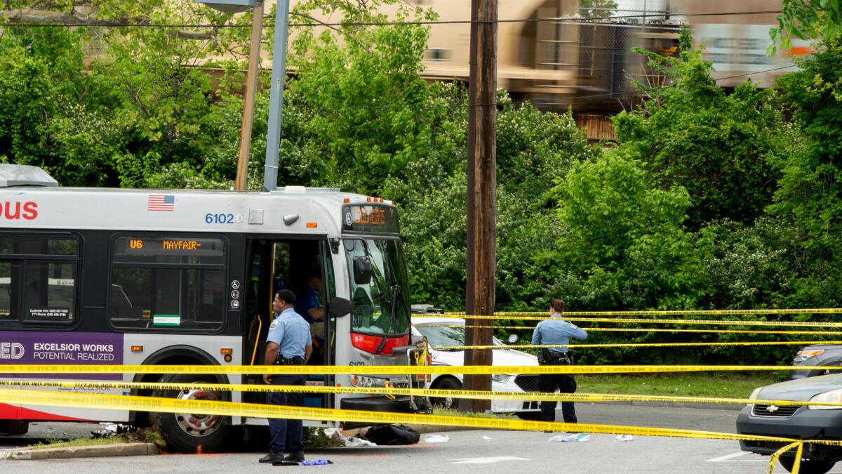 Police work a crime scene after a man attacked a bus driver, stole the bus, then struck and killed a pedestrian in northwest Washington, D.C.