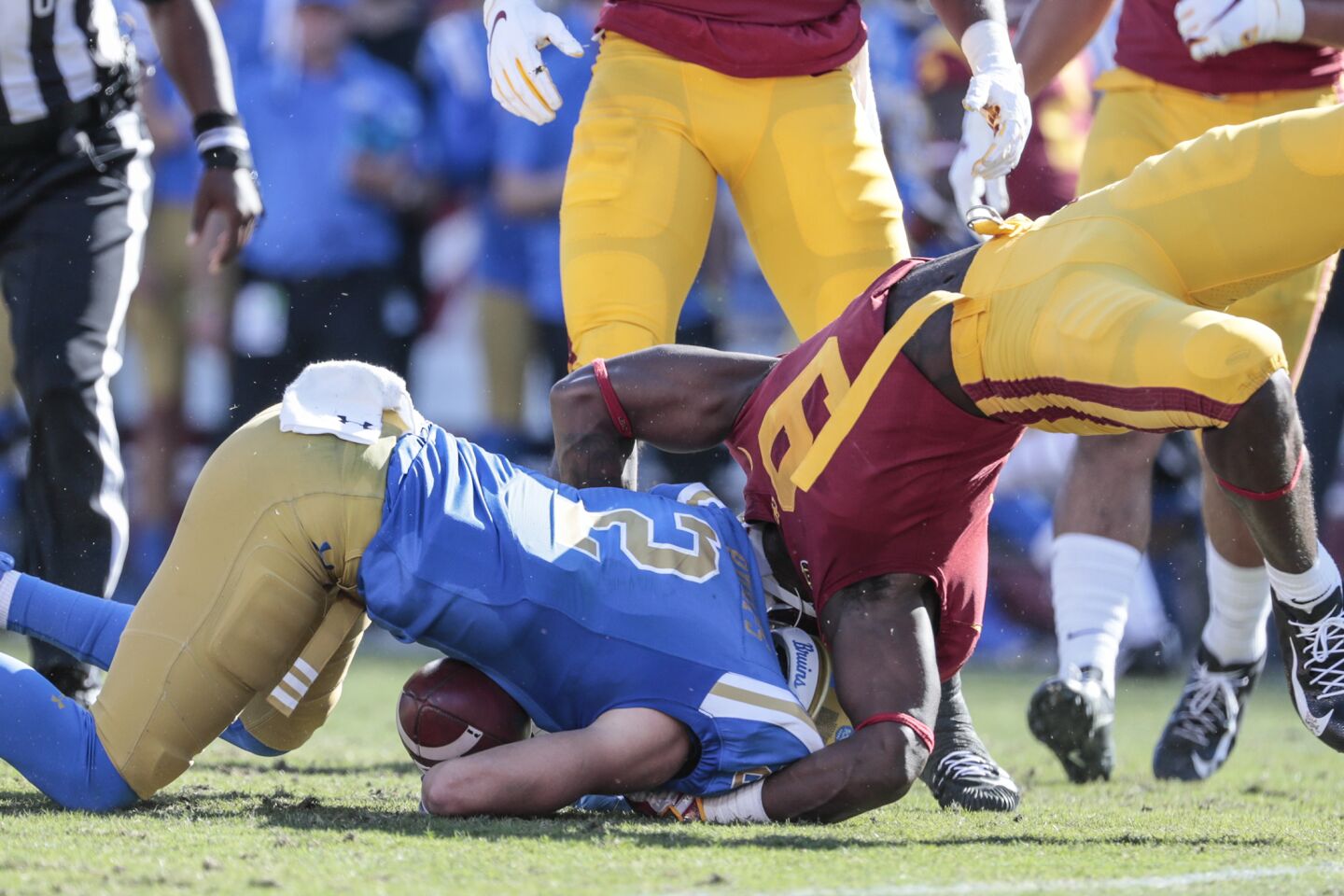 UCLA wide receiver Kyle Philips (2) is tackled by USC cornerback Greg Johnson (9) during first half action at the Coliseum on Saturday.