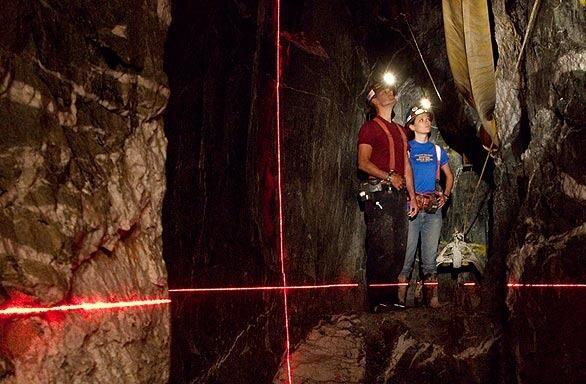 Stacy Rhoades, left, manager of Sutter Gold Mining Inc., and Holly Boitano, the firm's health, safety and environmental protection coordinator, demonstrate a laser surveying tool in the mine the company wants to reopen in Sutter Creek, Calif.